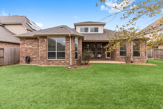 rear view of property featuring a yard and a patio area