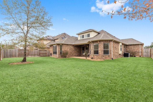 rear view of house featuring cooling unit, a yard, and a patio