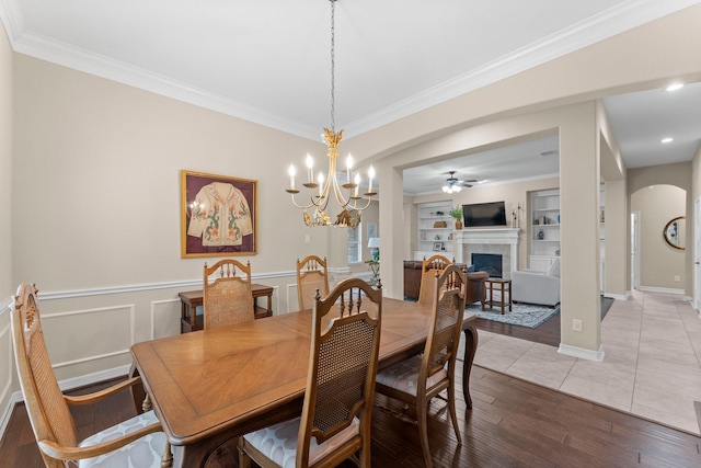 dining room featuring crown molding, light hardwood / wood-style flooring, ceiling fan, and built in shelves