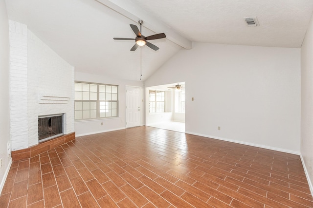 unfurnished living room with ceiling fan, lofted ceiling with beams, a textured ceiling, and a brick fireplace