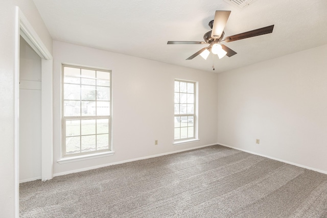 empty room with ceiling fan and carpet floors