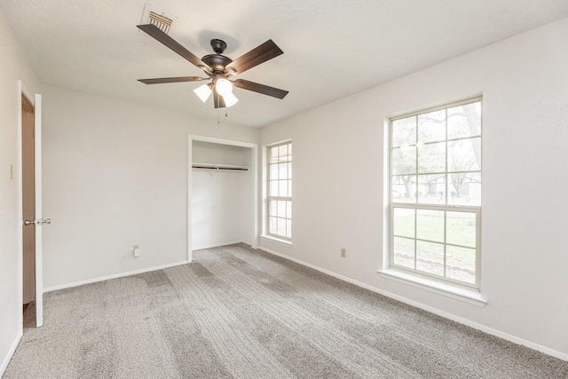 unfurnished bedroom with carpet floors, a closet, and ceiling fan