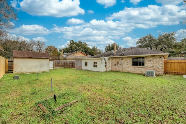 rear view of house featuring a yard, cooling unit, and a storage unit