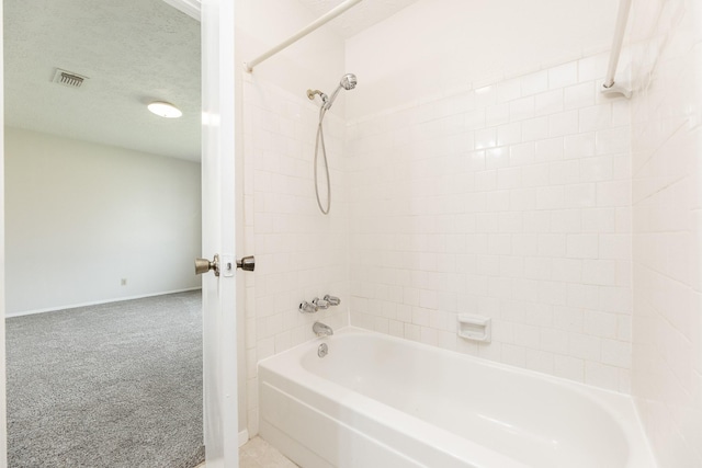 bathroom with shower / tub combination and a textured ceiling