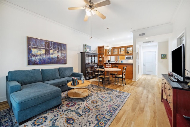 living room with ceiling fan, light hardwood / wood-style floors, and ornamental molding