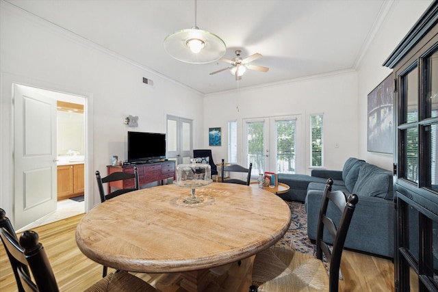 dining area featuring french doors, light hardwood / wood-style flooring, ceiling fan, and ornamental molding