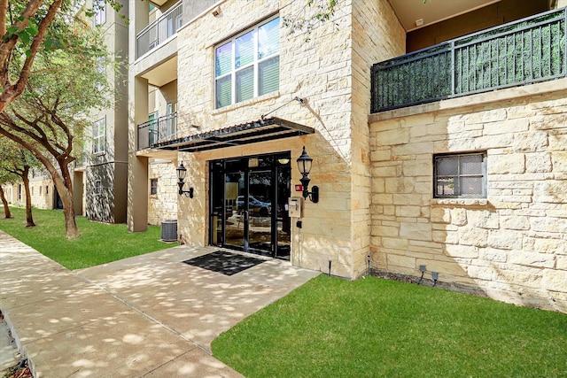 entrance to property featuring a balcony and a patio