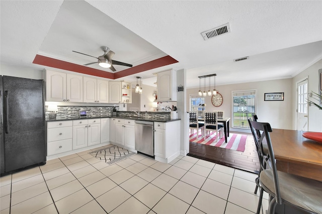 kitchen featuring visible vents, white cabinets, decorative light fixtures, freestanding refrigerator, and stainless steel dishwasher