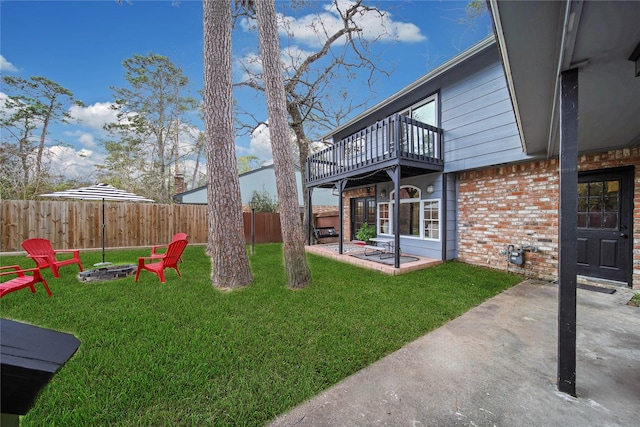 view of yard featuring fence, a fire pit, a deck, and a patio