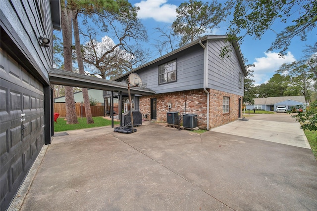 view of home's exterior featuring a patio, fence, cooling unit, and brick siding