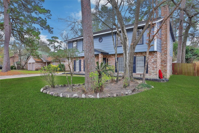 colonial home with a chimney, a front lawn, and brick siding