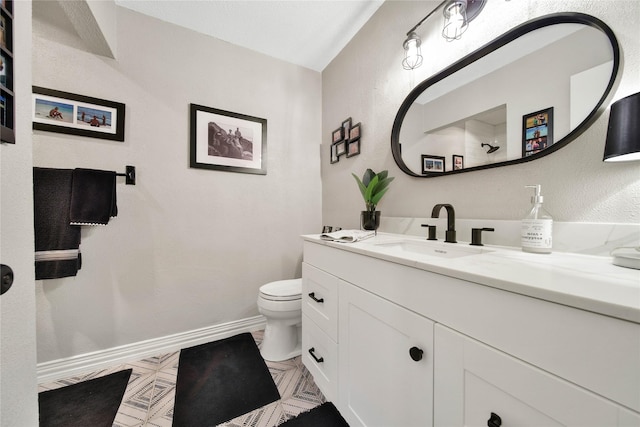 bathroom with vanity, toilet, and baseboards