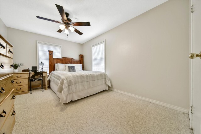 bedroom with light carpet, ceiling fan, and baseboards