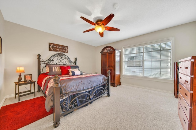 bedroom with light carpet, ceiling fan, and baseboards