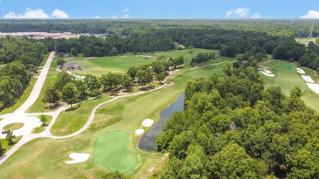 drone / aerial view featuring a water view, a view of trees, and golf course view