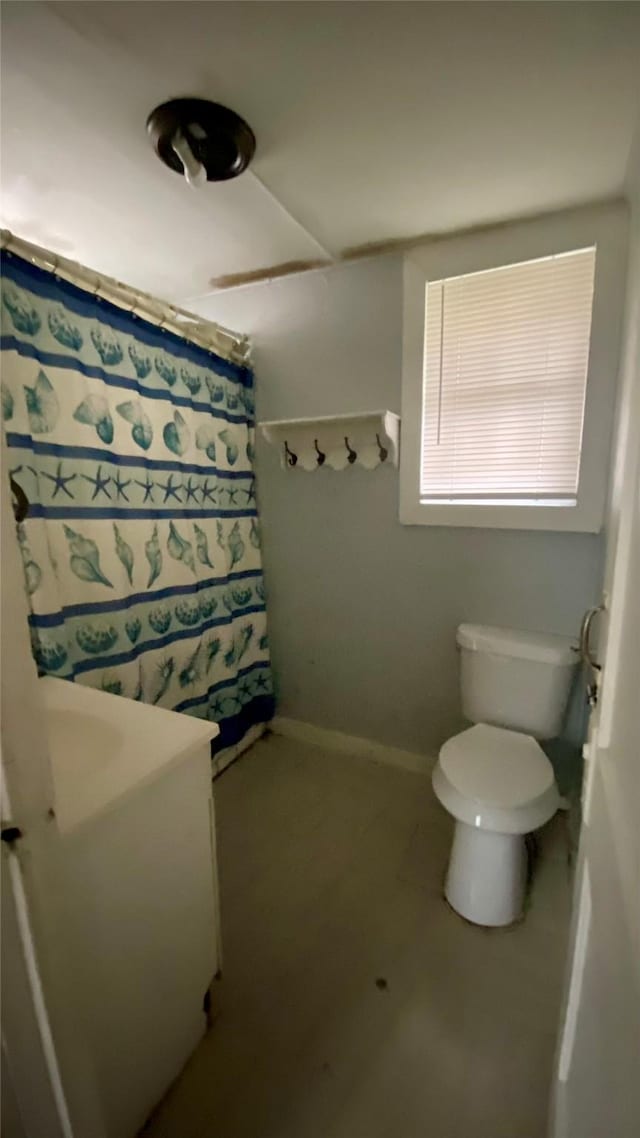 bathroom with curtained shower and toilet