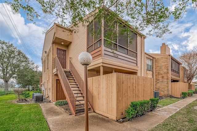 back of house with cooling unit and a yard