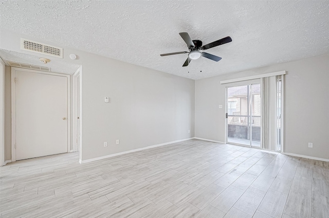 empty room with ceiling fan and a textured ceiling