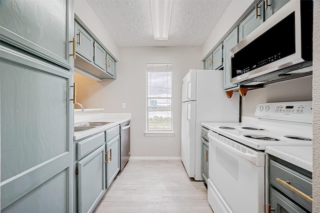 kitchen with sink, stainless steel appliances, and a textured ceiling