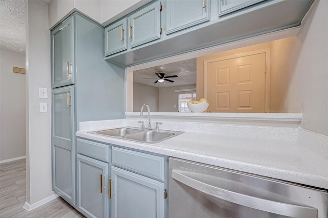 kitchen with light wood-type flooring, a textured ceiling, ceiling fan, sink, and dishwasher