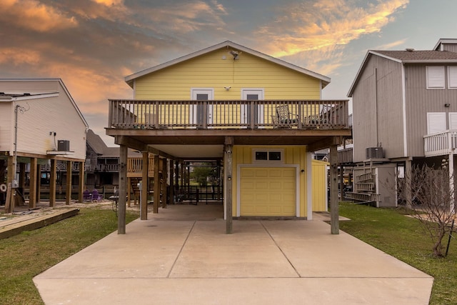 view of front of home with a yard, a garage, a carport, and a wooden deck