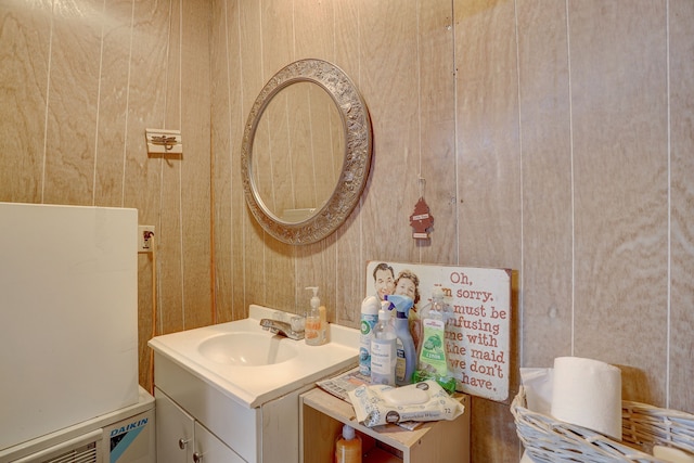 bathroom featuring wooden walls and vanity