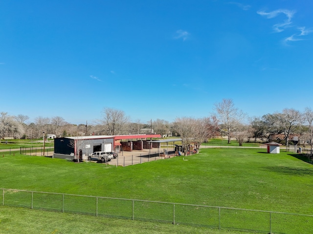 view of property's community featuring a lawn and an outdoor structure