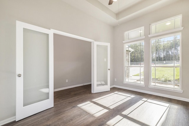 interior space featuring ceiling fan, french doors, dark wood-type flooring, a raised ceiling, and a towering ceiling