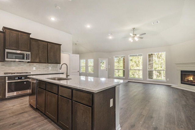 kitchen featuring sink, stainless steel appliances, dark hardwood / wood-style floors, an island with sink, and decorative backsplash