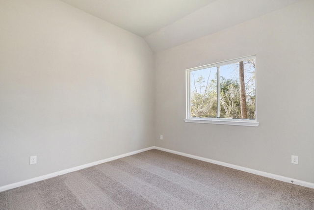 carpeted spare room with lofted ceiling