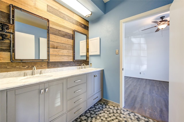 bathroom featuring vanity, wood walls, and ceiling fan