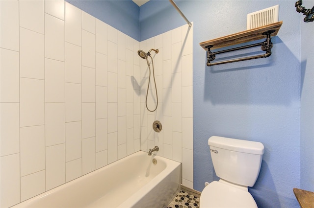 bathroom with tiled shower / bath and toilet