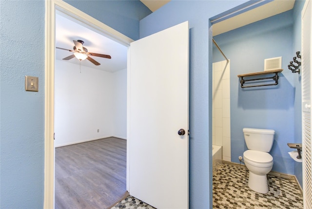 bathroom with ceiling fan, shower / bath combination, wood-type flooring, and toilet