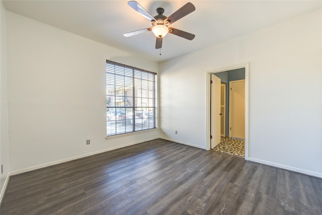 spare room with ceiling fan and dark wood-type flooring