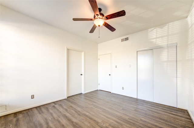 unfurnished bedroom featuring hardwood / wood-style floors, a closet, and ceiling fan