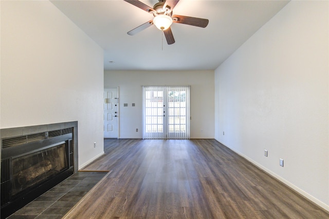 unfurnished living room featuring french doors, dark hardwood / wood-style flooring, a fireplace, and ceiling fan