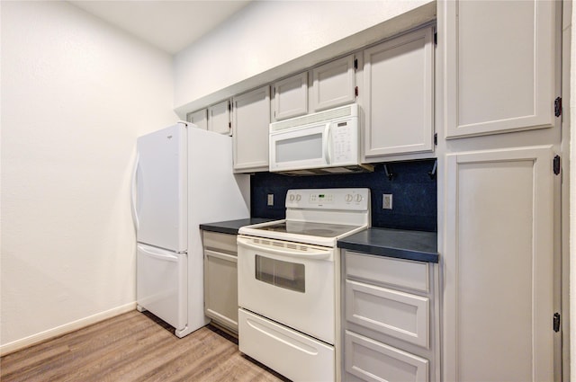 kitchen with white appliances, light hardwood / wood-style floors, white cabinetry, and decorative backsplash