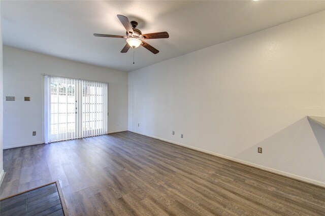 unfurnished room featuring dark wood-type flooring and ceiling fan