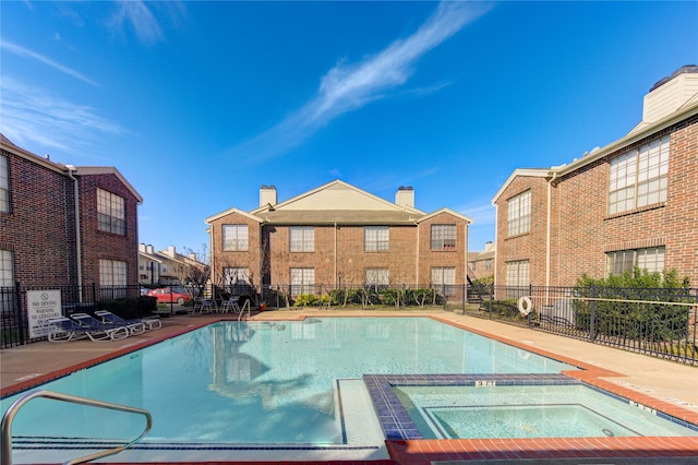 view of swimming pool with a hot tub