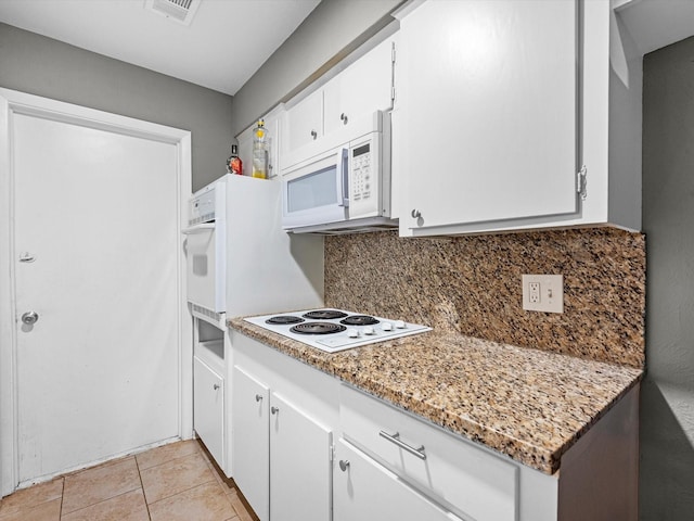 kitchen with white cabinetry, light stone countertops, tasteful backsplash, white appliances, and light tile patterned floors