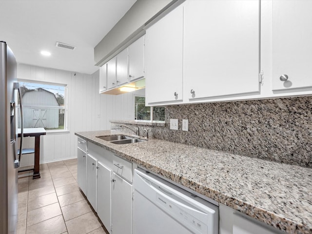 kitchen with light stone countertops, sink, stainless steel fridge with ice dispenser, white dishwasher, and white cabinets