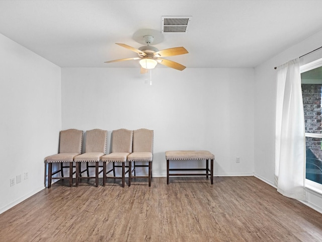 living area with hardwood / wood-style floors and ceiling fan