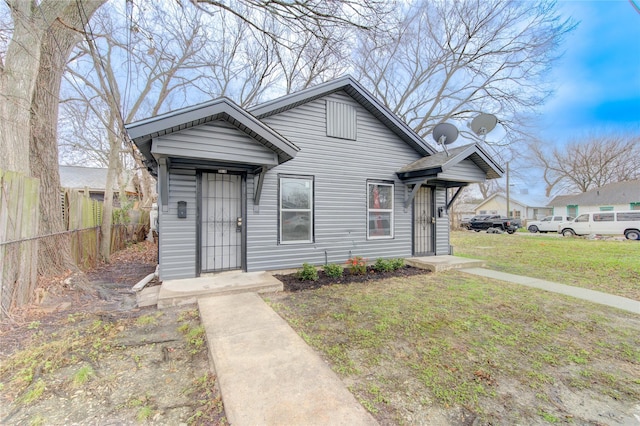 bungalow-style home with a front lawn