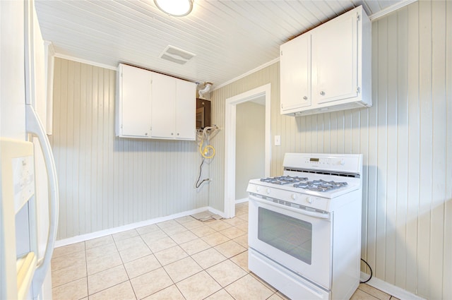 kitchen featuring white cabinets, white appliances, wooden walls, light tile patterned floors, and ornamental molding