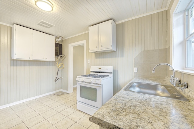 kitchen with white cabinetry, sink, white range with gas cooktop, light tile patterned floors, and ornamental molding