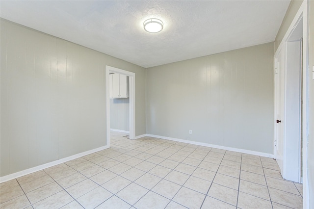 tiled spare room featuring a textured ceiling