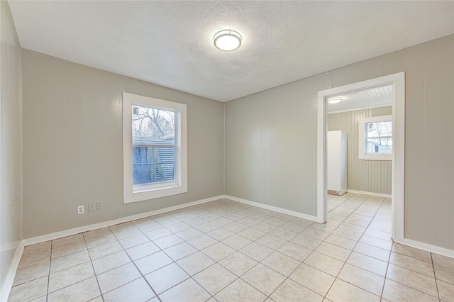 tiled spare room with a textured ceiling