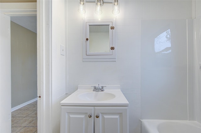 bathroom featuring tile patterned flooring, vanity, and a tub to relax in