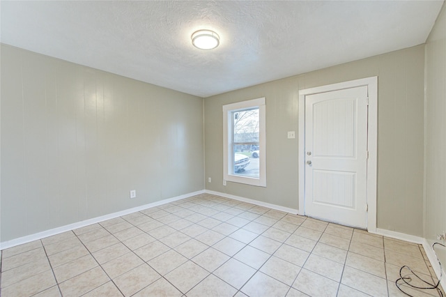 spare room with light tile patterned floors and a textured ceiling