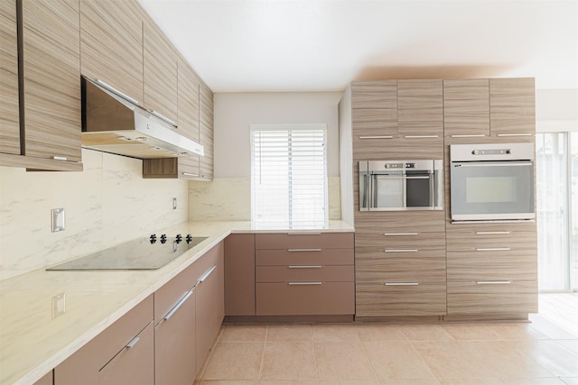 kitchen with stainless steel oven, white oven, black electric cooktop, exhaust hood, and light tile patterned floors